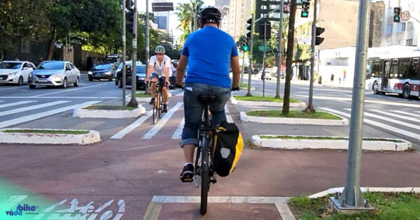 ciclista pedalando em ciclovia, com outra bicicleta vindo no sentido contrário