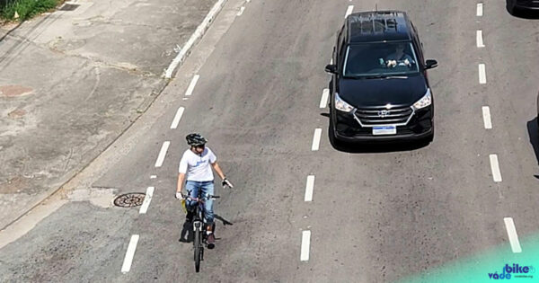 ciclista sinalizando para motorista em avenida